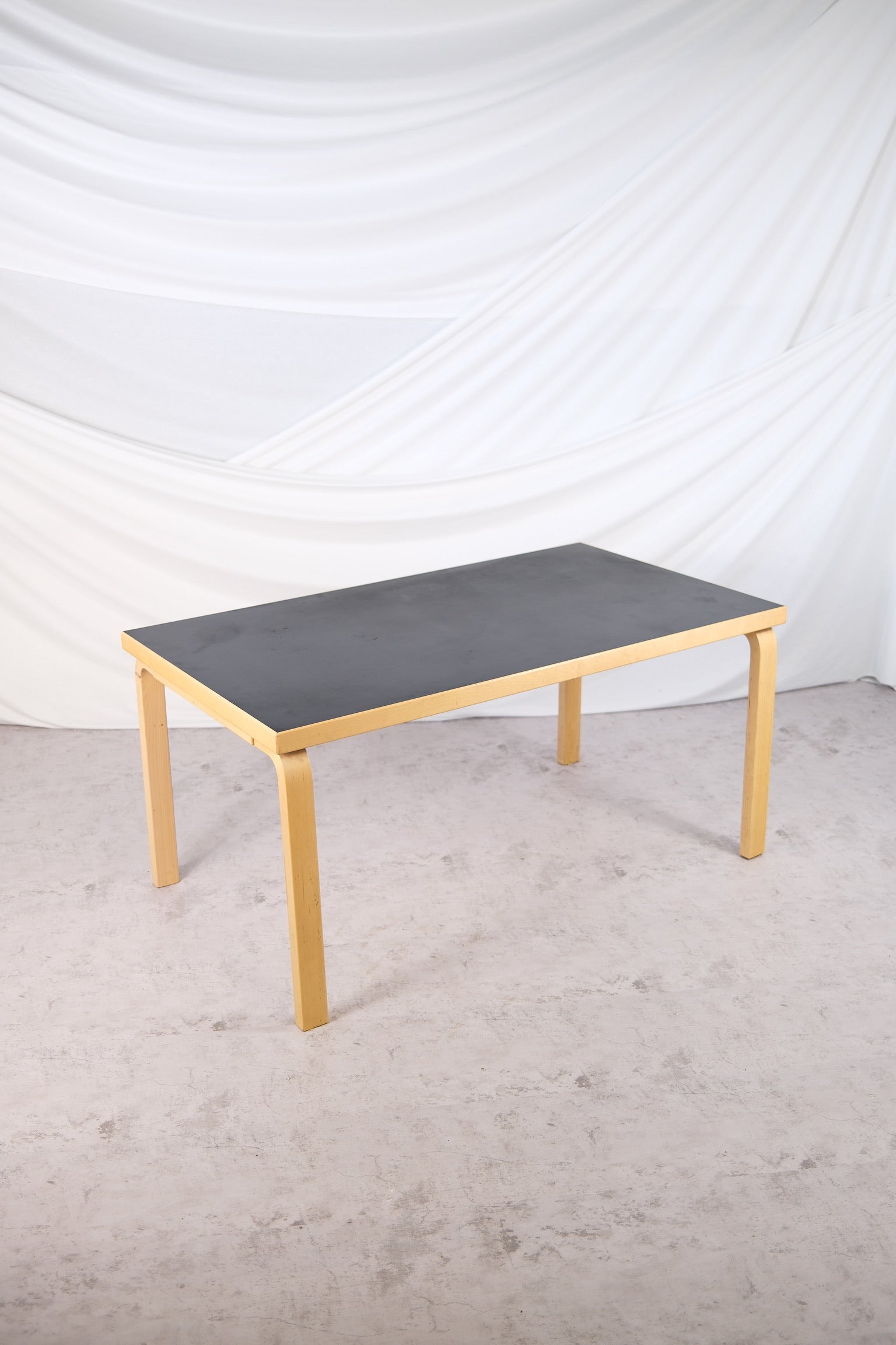 Artek 82A dining table with black linoleum top and birch frame by Alvar Aalto
Side view of Artek 82A table, black linoleum top, Finnish design classic
Detail of birch legs and black linoleum tabletop on Alvar Aalto’s 82A table
Vintage Artek 82A table in black linoleum and birch, Scandinavian design
Finnish modernist table by Alvar Aalto, Artek 82A model with black linoleum