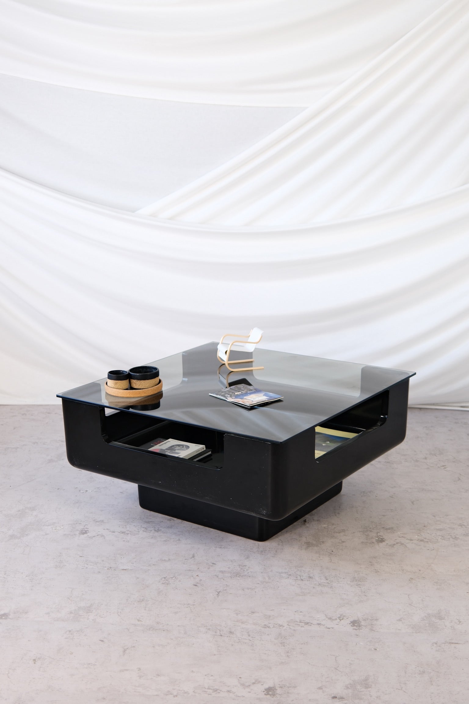 Eero Aarnio black fiberglass coffee table with smoked glass top and integrated storage, 1970s Finnish design.