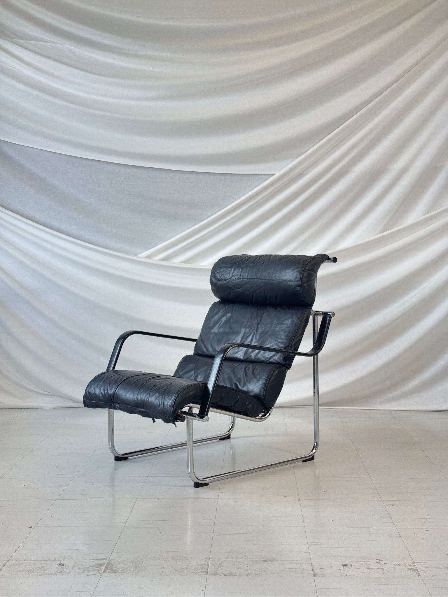 Vintage Yrjö Kukkapuro Remmi lounge chair with black leather cushions and chrome tubular steel frame, produced by Avarte Finland.
