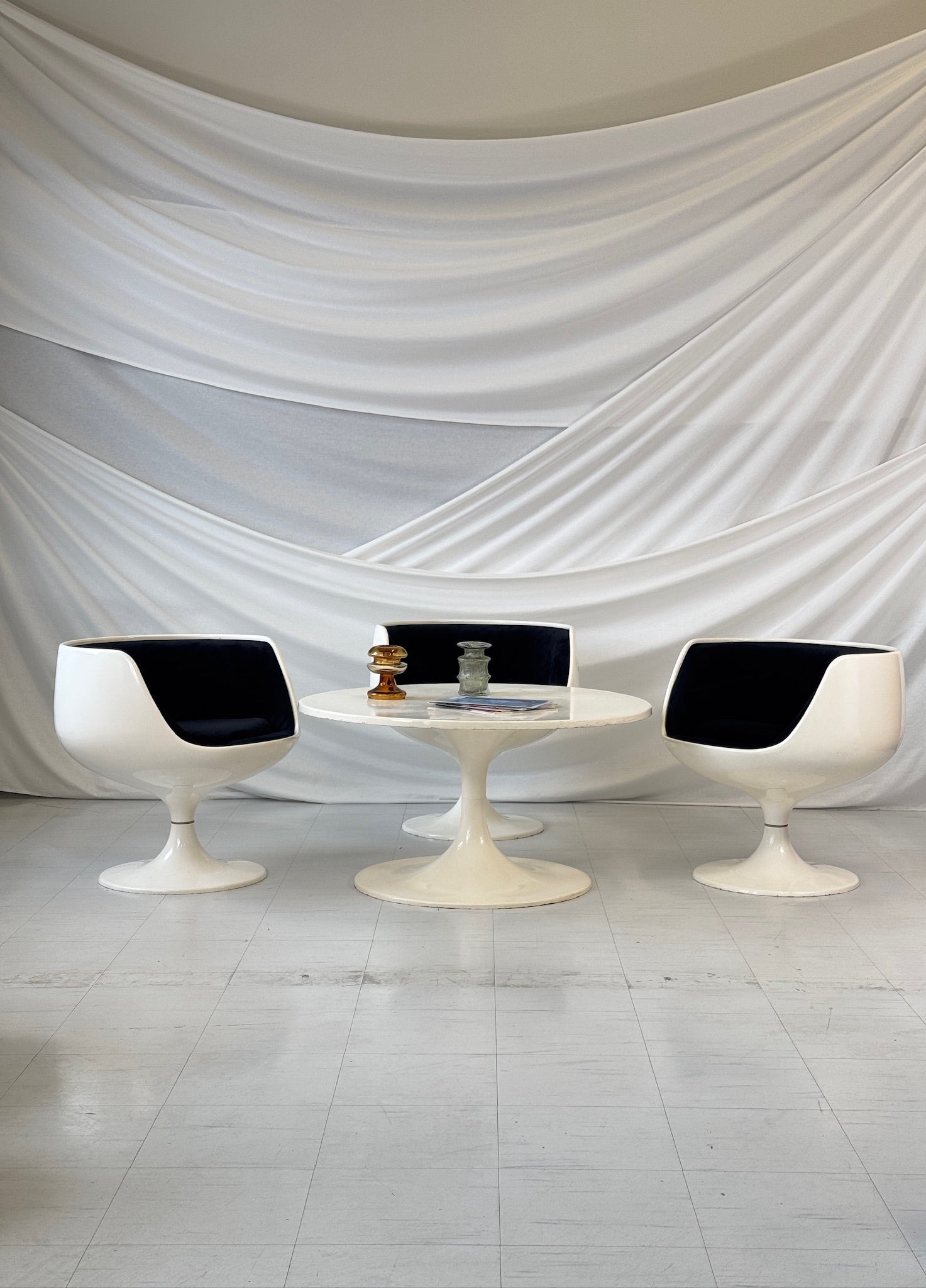 Eero Aarnio Cognac chairs in white fiberglass with black velvet upholstery and tulip table, 1970s Finnish design.