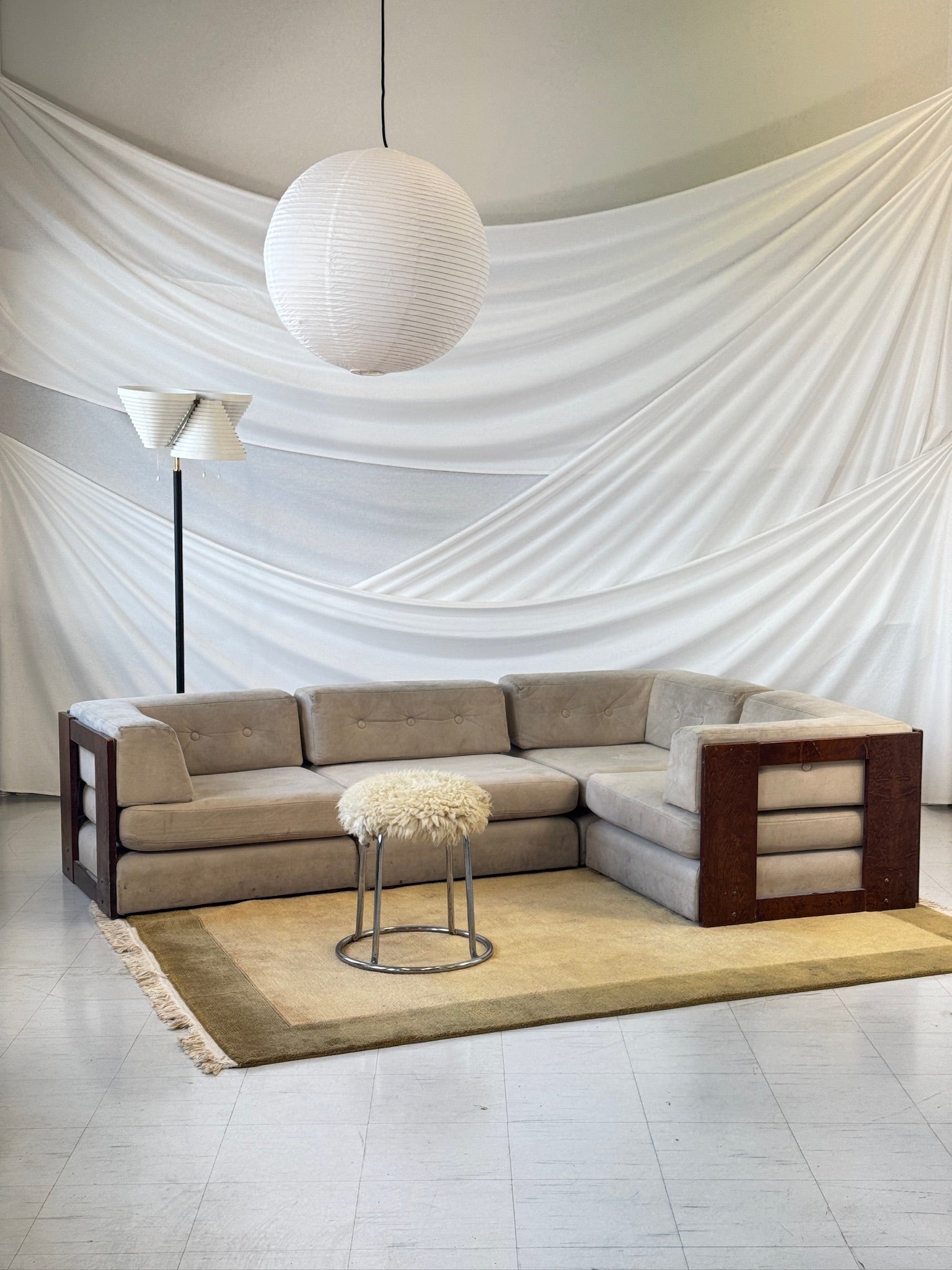 Vilka modular sofa in four pieces with exposed wooden frame and light grey Alcantara upholstery.