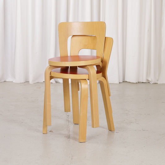 Stacked Artek Chair 65 chairs in birch and red linoleum