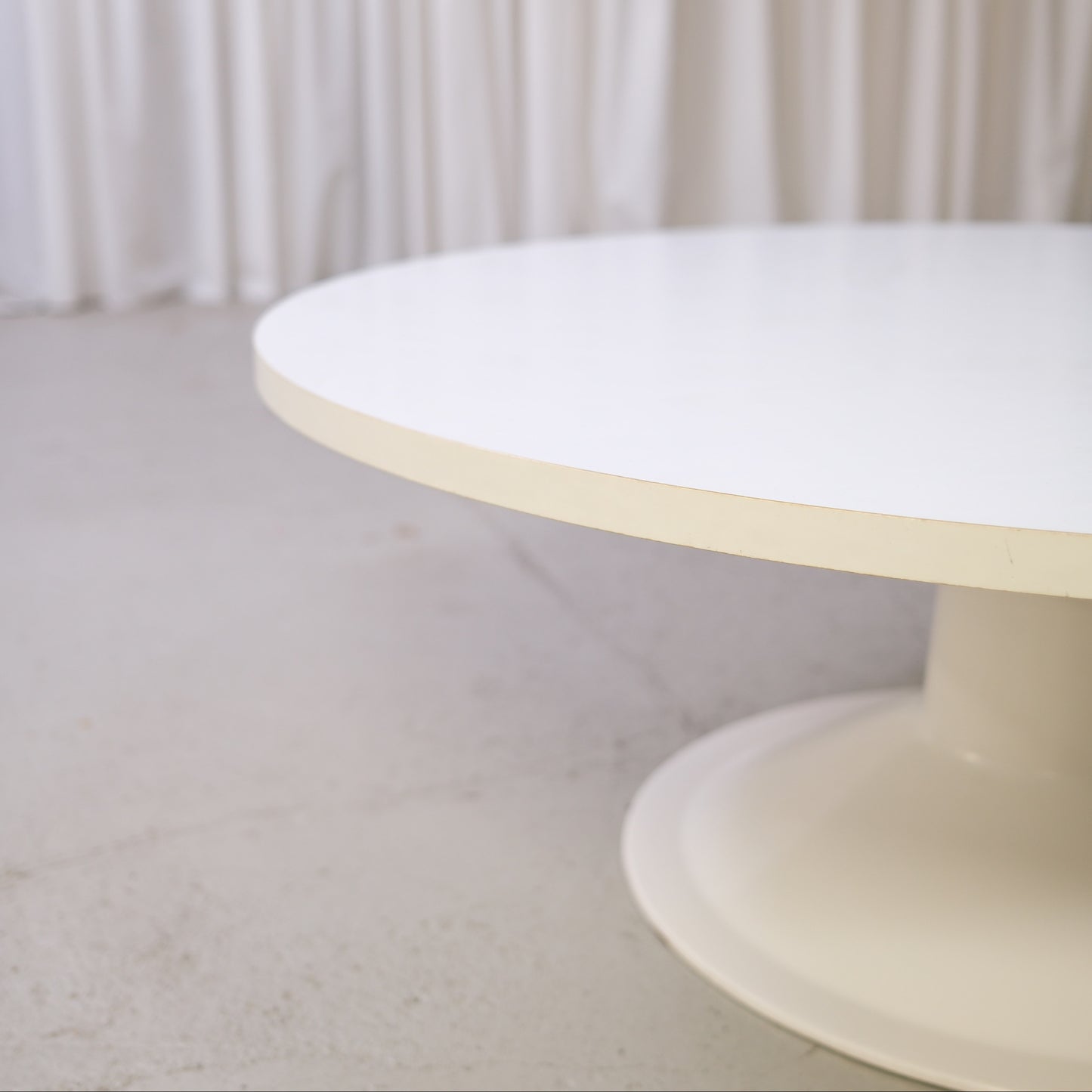 Detail of the white tabletop edge and cream fibreglass base