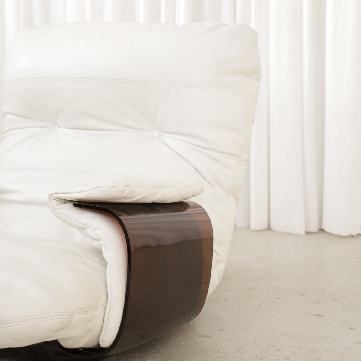 Detail of white chair back and curved side panel