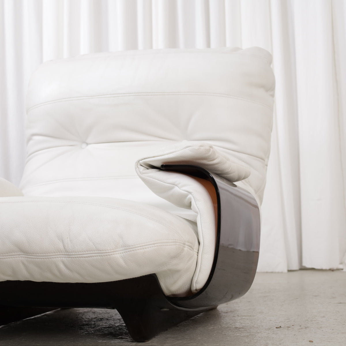 Detail of white chair armrest and dark frame