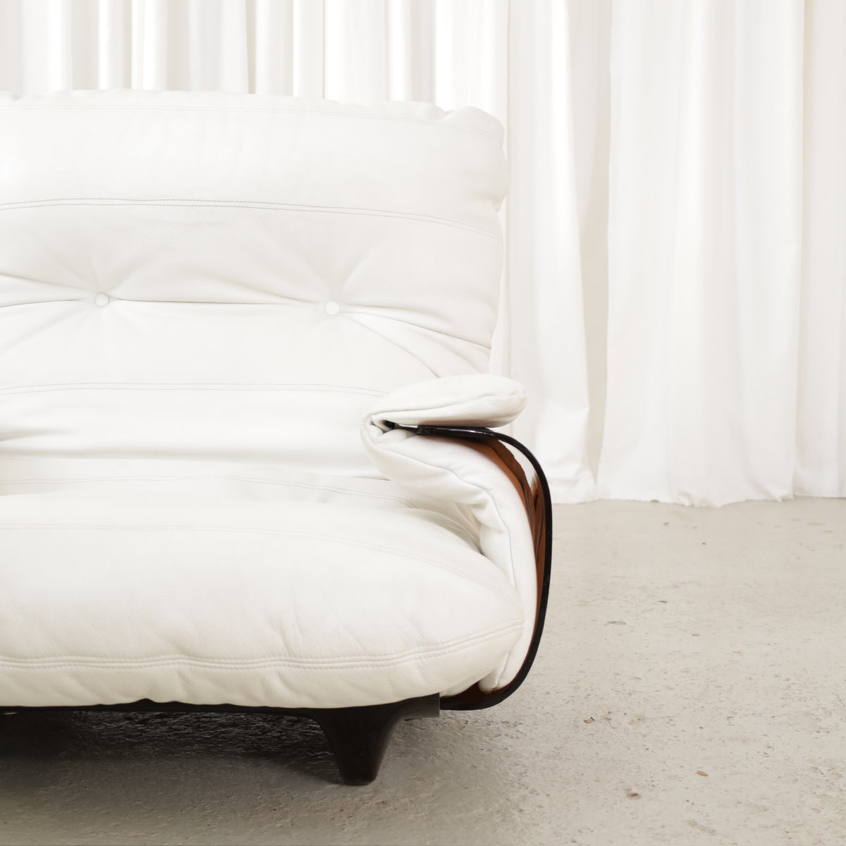 Detail of white chair back and dark armrest