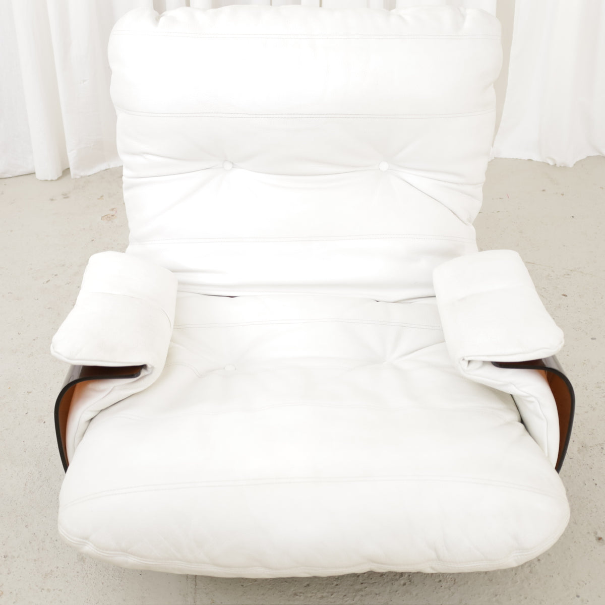 Close view of white chair upholstery and padded armrests