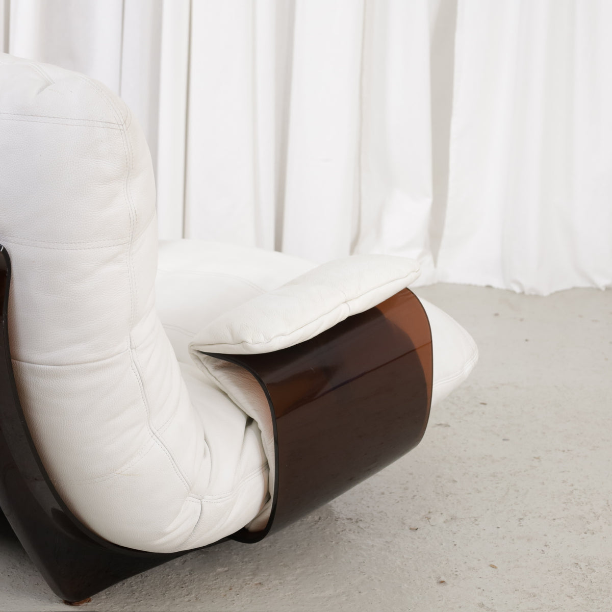 Close view of white upholstery and dark curved armrest