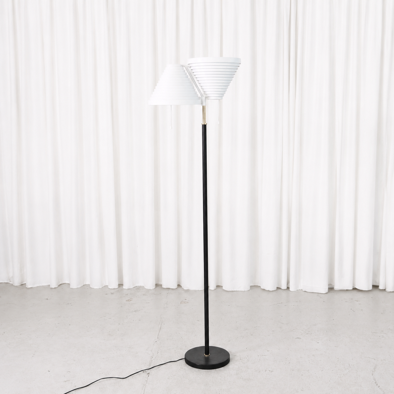 1970s Alvar Aalto A810 floor lamp by Valaisinpaja. Black stem, brass details and white shade. Very clean vintage condition.