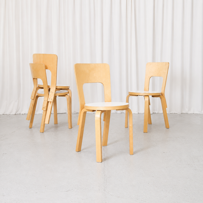 Vintage Alvar Aalto Artek 66 chairs with natural birch frames and white laminate seats. A classic Finnish design with timeless, practical proportions.