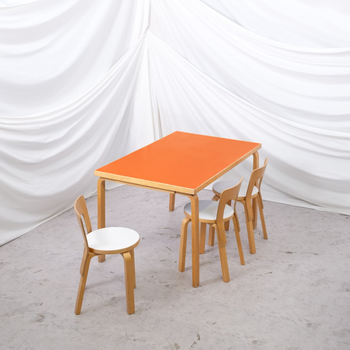 Vintage Artek 81B table by Alvar Aalto with orange laminate top and birch L-legs. Finnish design classic. Worldwide shipping available