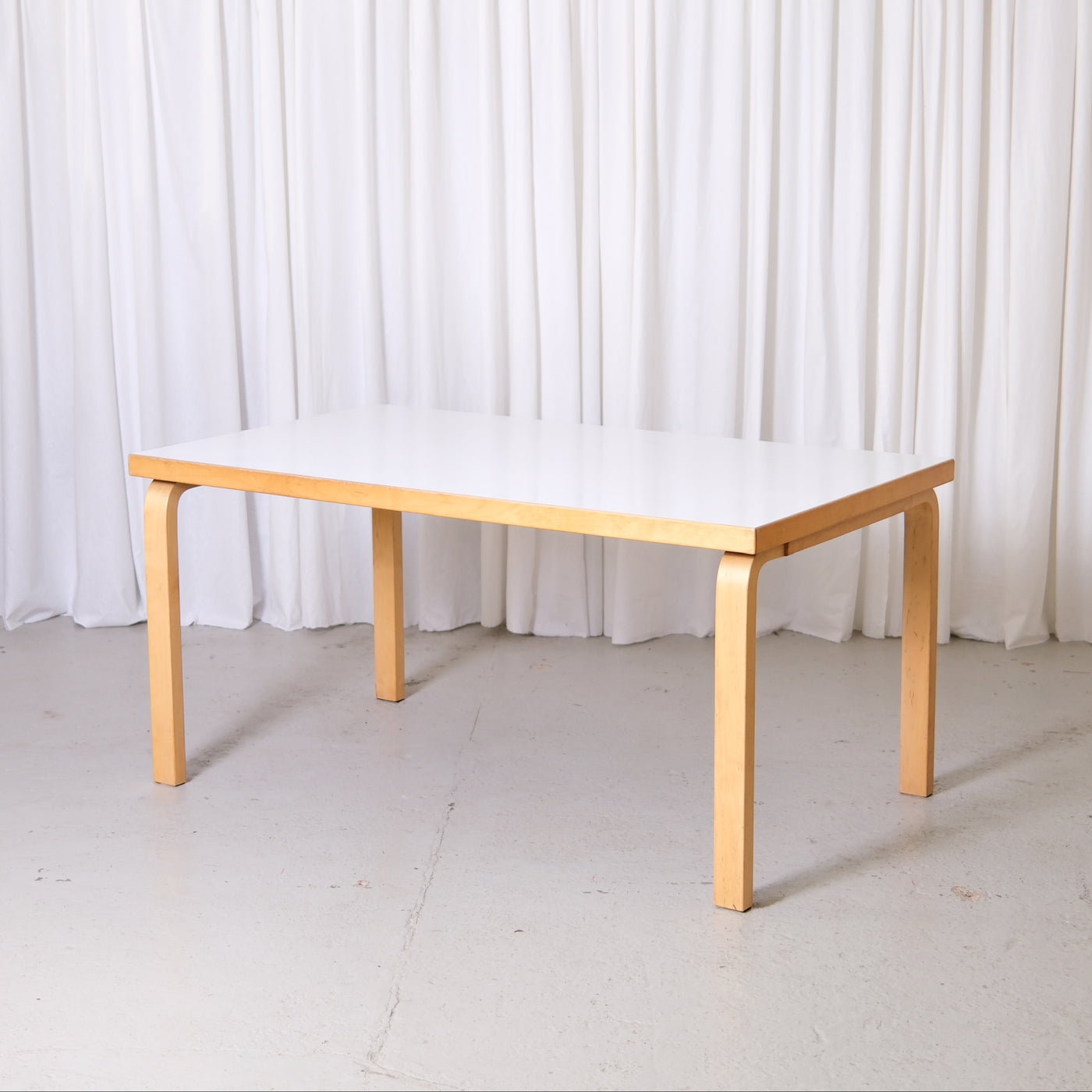 Vintage Artek 82A table by Alvar Aalto with white laminate top and birch legs. Finnish design classic from Helsinki with worldwide shipping available.