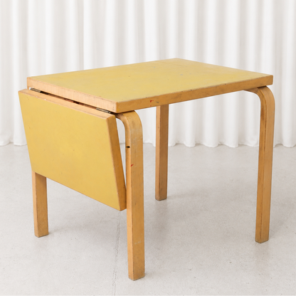 Vintage Alvar Aalto DL82 drop-leaf table for Artek with a yellow linoleum top and birch frame. A compact Finnish design classic with authentic patina.