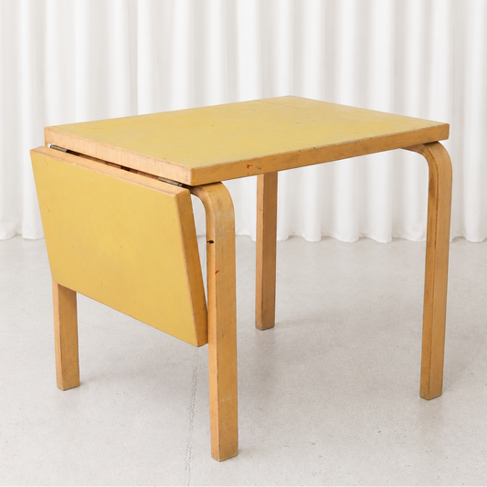 Vintage Alvar Aalto DL82 drop-leaf table for Artek with a yellow linoleum top and birch frame. A compact Finnish design classic with authentic patina.