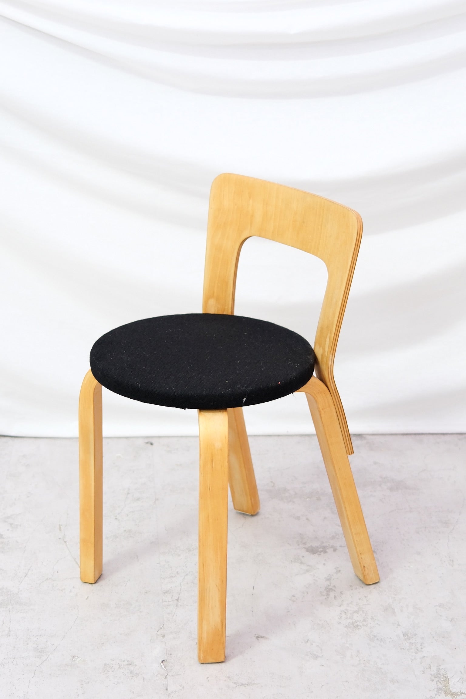 Original vintage Artek 65 chair by Alvar Aalto in natural birch with black seat. Classic Finnish design from Helsinki. Worldwide shipping available.
