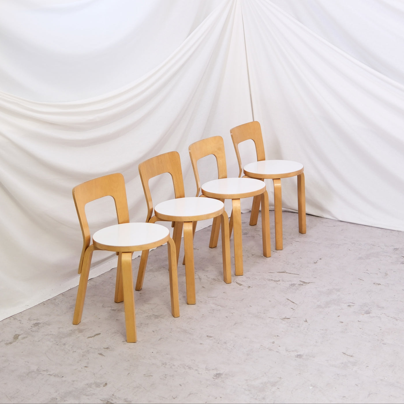 Vintage Artek 65 chairs by Alvar Aalto with white laminate seats and birch frames. Sold individually. Helsinki availability, delivery in Finland upon request, worldwide shipping.