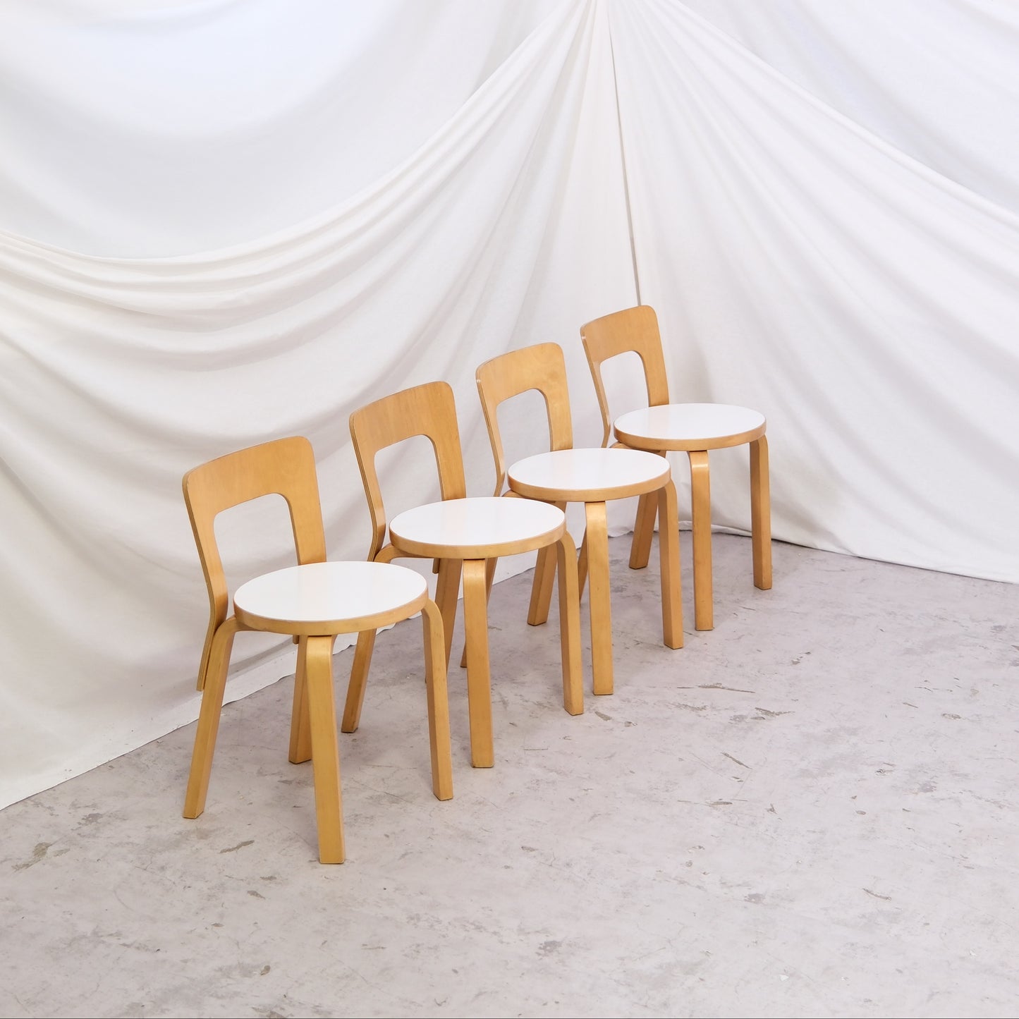 Vintage Artek 65 chairs by Alvar Aalto with white laminate seats and birch frames. Sold individually. Helsinki availability, delivery in Finland upon request, worldwide shipping.