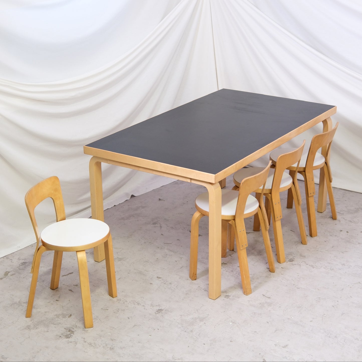 Vintage Artek 82A table by Alvar Aalto with black linoleum top and birch legs. Size 150 x 85 cm. Available in Helsinki with worldwide shipping and delivery in Finland.