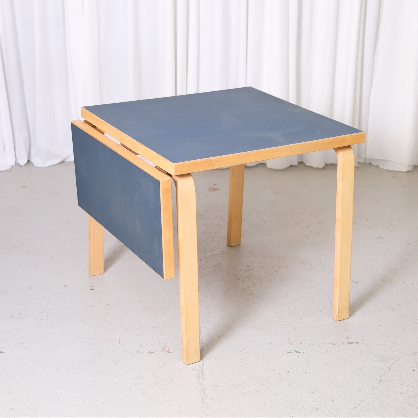 Artek Aalto DL81C drop-leaf table with dark blue linoleum top and birch frame
