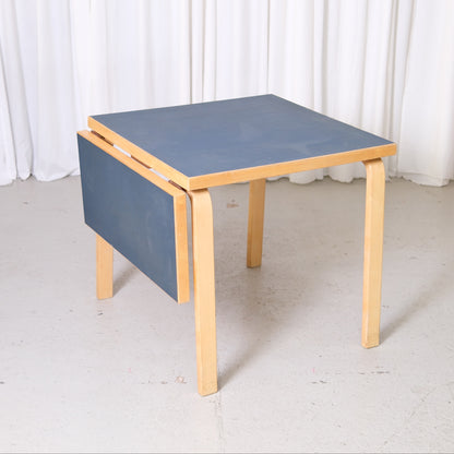 Artek Aalto DL81C drop-leaf table with dark blue linoleum top and birch frame

