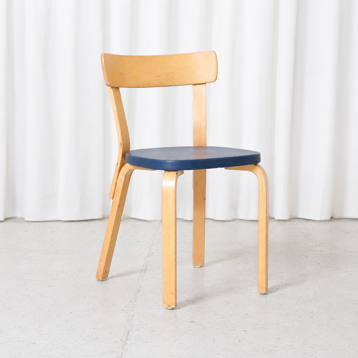 Vintage Artek Chair 69 designed by Alvar Aalto, featuring a natural birch frame and blue vinyl upholstered seat. Good condition with light wear and patina.