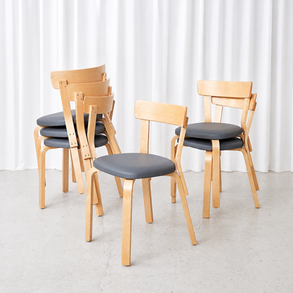 Vintage Artek Chair 69 by Alvar Aalto with a natural birch frame and grey upholstered seat. A timeless classic of Finnish design.