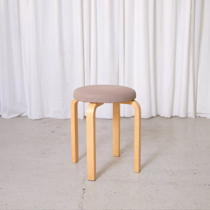 Vintage Artek E60 stool by Alvar Aalto with birch legs and Artek fabric upholstered round seat.