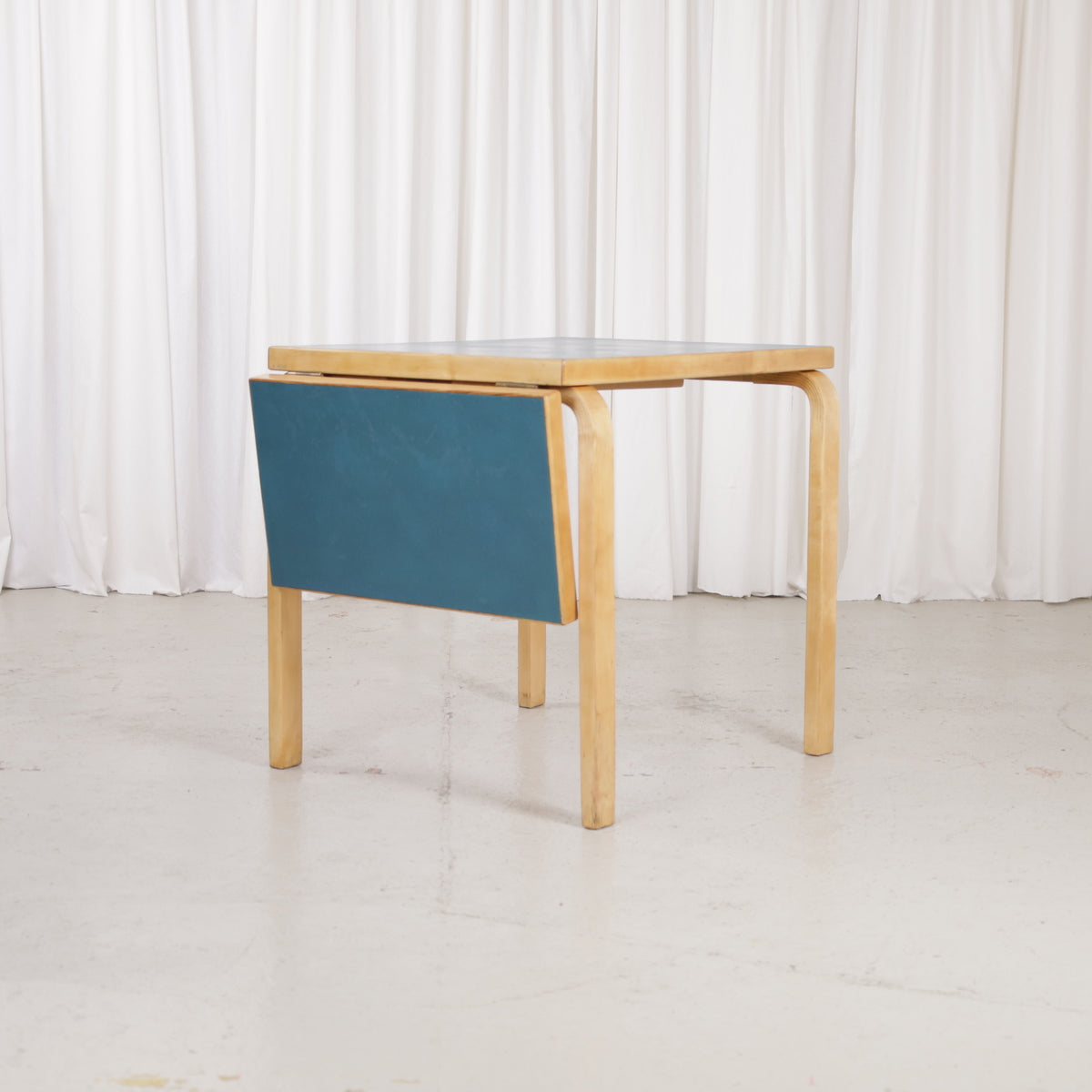 Artek DL82 table with petrol blue linoleum leaf folded down