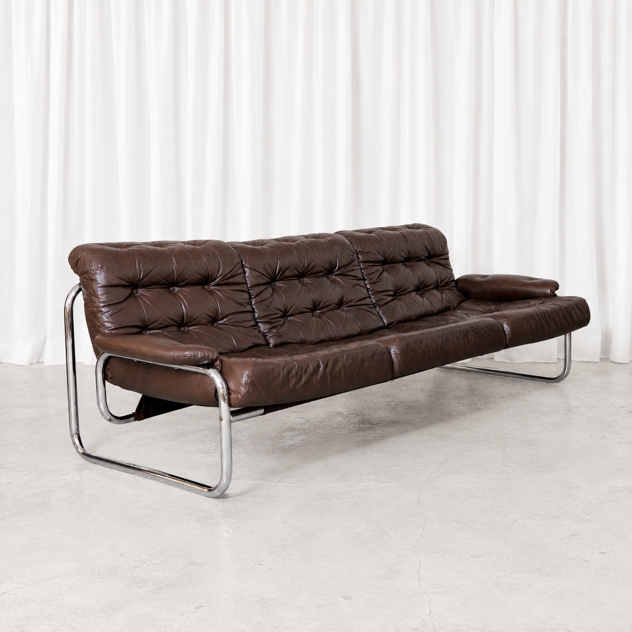 Vintage Borkum three-seater sofa by Johan Bertil Häggström for IKEA, featuring button-tufted brown leather and a chrome tubular frame.