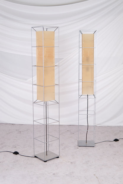 Two modern floor lamps with beige lampshades on a white background