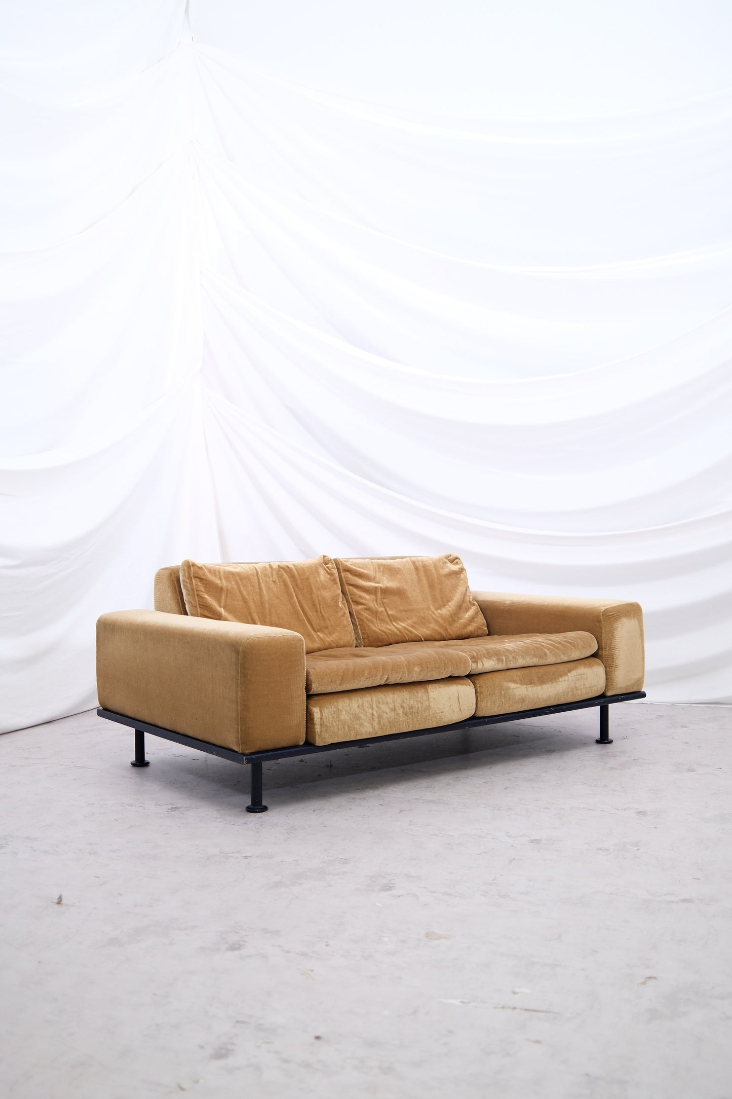 Yrjö Kukkapuro Variation sofa in green-yellow velvet with black steel frame, photographed against a white draped backdrop.