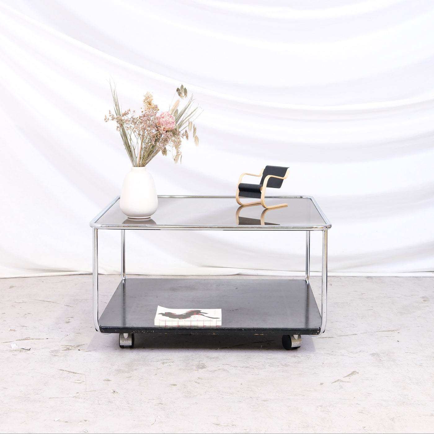 Vintage Hannibal coffee table by Kurt Hvitsjö for Isku. Smoked glass top, black lower shelf, and wheels. Size 70 x 70 cm. Worldwide shipping available.
