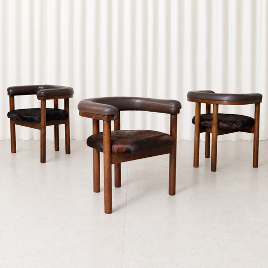 Rare set of three dining chairs by Esko Pajamies for Lepo Finn, featuring wooden frames, curved upholstered backrests and individual cowhide seats.