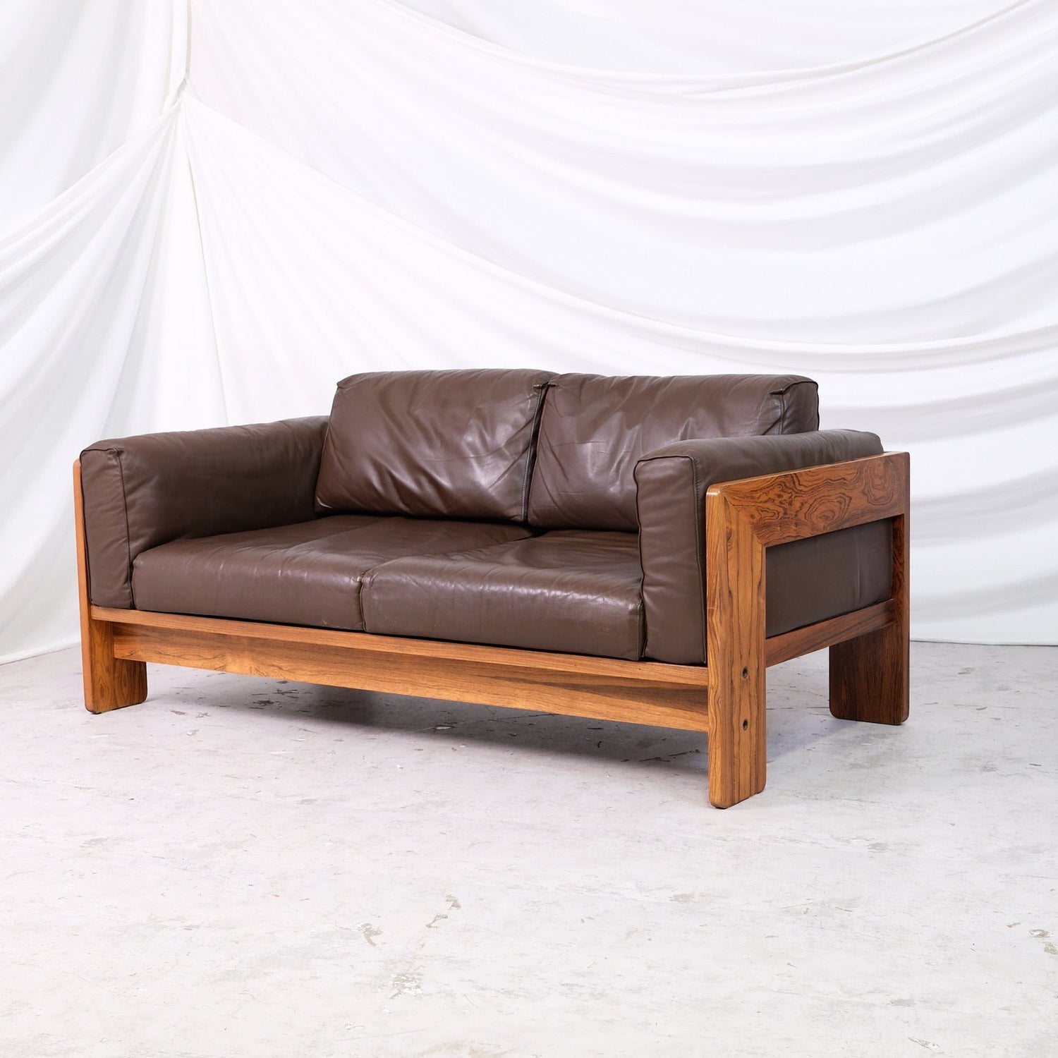 Vintage Tobia Scarpa Bastiano two-seater sofa in dark brown leather with wooden frame.
