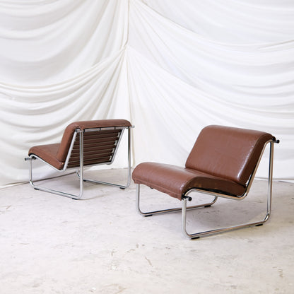 Vintage Yrjö Kukkapuro Remmi low lounge chairs with brown leather upholstery and chrome tubular frames. Sold individually or as a pair. Worldwide shipping available.