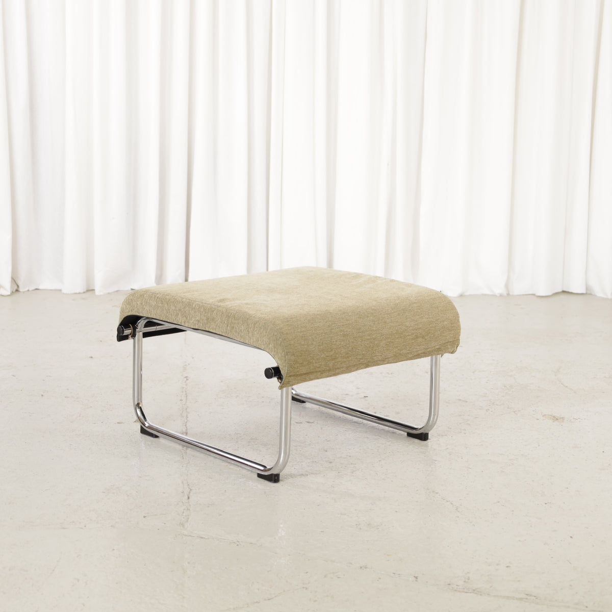 Remmi ottoman with chrome frame, angled view