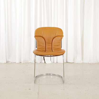 Cidue dining chairs in cognac leather with polished chrome cantilever frames and detailed padded backs