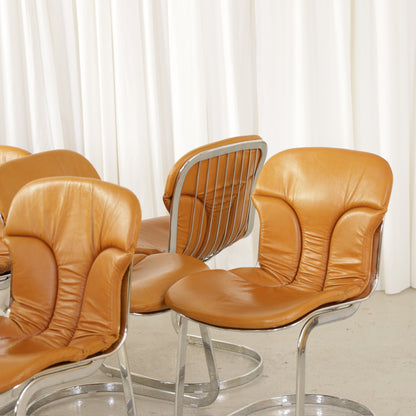 Cidue dining chairs in cognac leather with polished chrome cantilever frames and detailed padded backs
