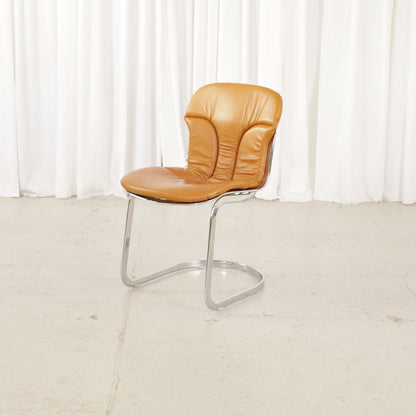 Cidue dining chairs in cognac leather with polished chrome cantilever frames and detailed padded backs