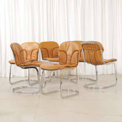 Cidue dining chairs in cognac leather with polished chrome cantilever frames and detailed padded backs