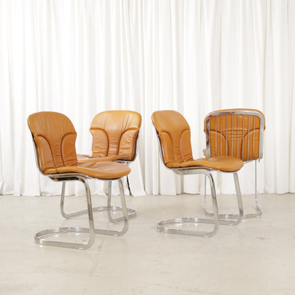 Cidue dining chairs in cognac leather with polished chrome cantilever frames and detailed padded backs