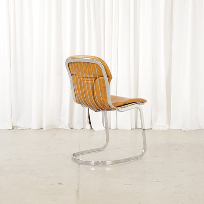 Cidue dining chairs in cognac leather with polished chrome cantilever frames and detailed padded backs
