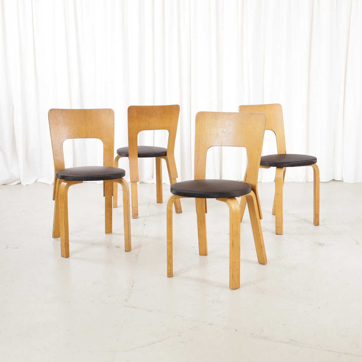 Four early Alvar Aalto Chair 66 examples in ash with dark fabric seats