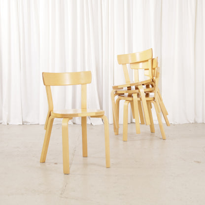 Artek Chair 69 beside three stacked matching chairs
