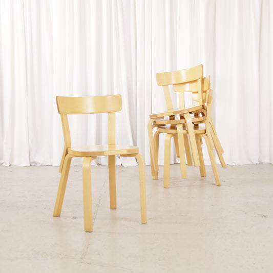 Artek Chair 69 beside three stacked matching chairs