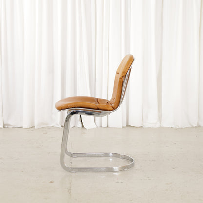 Cidue dining chairs in cognac leather with polished chrome cantilever frames and detailed padded backs