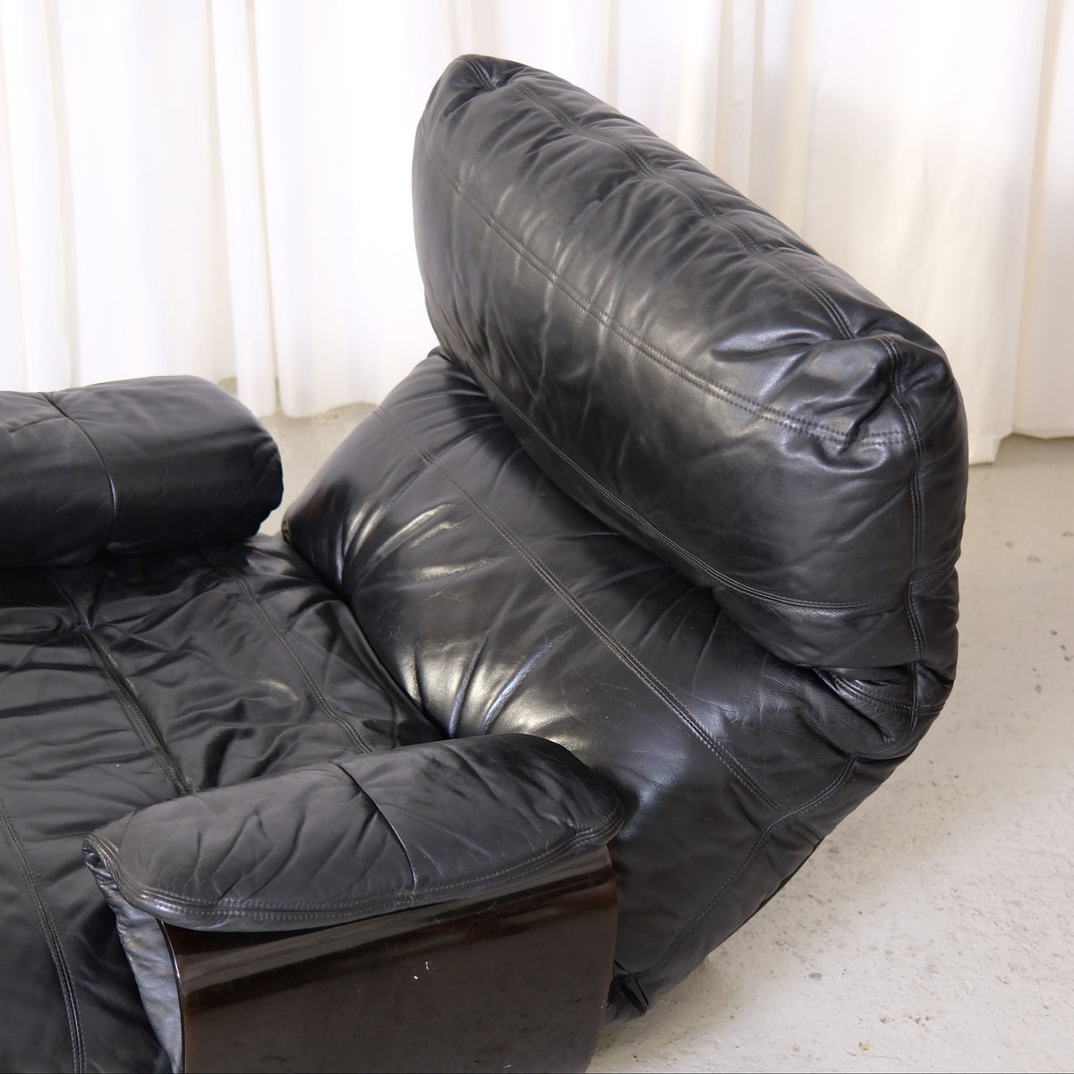 Detail of black leather backrest and padded armrest