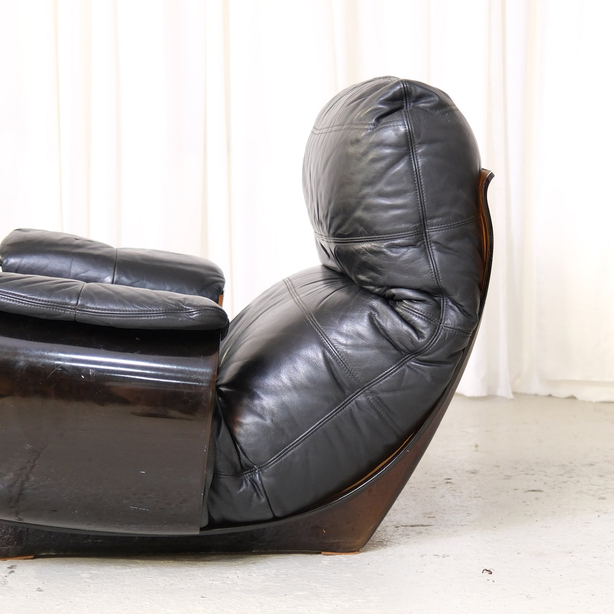 Detail of black leather cushion and smoked acrylic armrest
