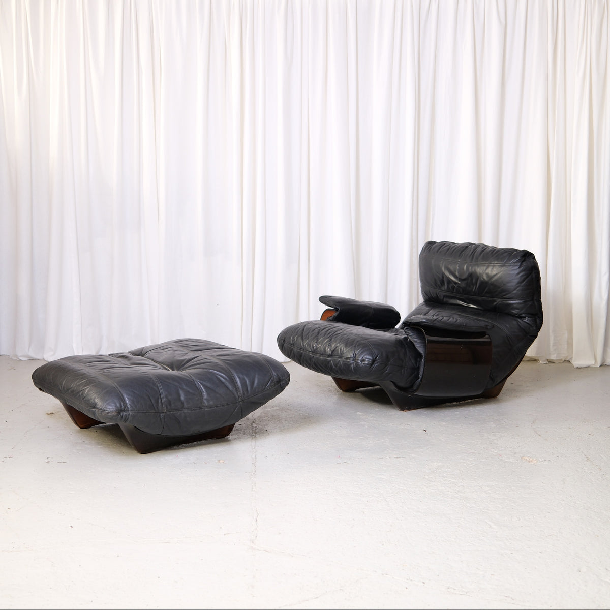 Marsala lounge chair and ottoman in black leather, front three-quarter view
