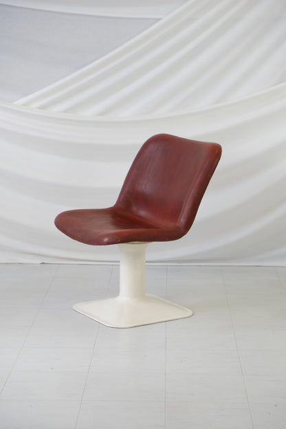 Yrjö Kukkapuro Big Junior chair in reddish-brown leather with white pedestal base, front view.
